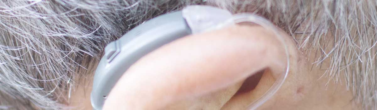 Primo piano di un apparecchio acustico BTE (Behind-The-Ear) con tubicino trasparente